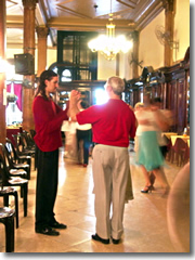 Gustavo, the postcard Argentine tango teacher, taking a coupel of tourists in hand to teach them the tango.