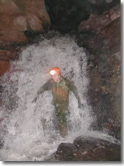 Nate Hirneisen washes off under an subterranean waterfall in in West Virginia's Mystic Cave.