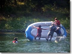 The boys learn river rescue techniques by purposefully flipping their raft, then learning to right it again in the rapids