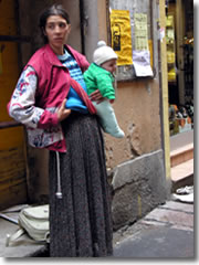 A gypsy woman begging--with an infant for sympathy points--outside a market in Bologna, Italy.