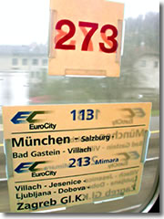Train car and line posters in teh window of a European rail car