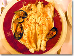 Enzo's spigola allo scoglio (sea bass cooked in foil with mussels, white wine, and spices) at U Bossu in Taormina, Sicily, Italy