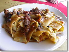 A heaping plate of Tuscany's famous pappardelle al chinghiale (sheet-like noodles with wild boar sauce).